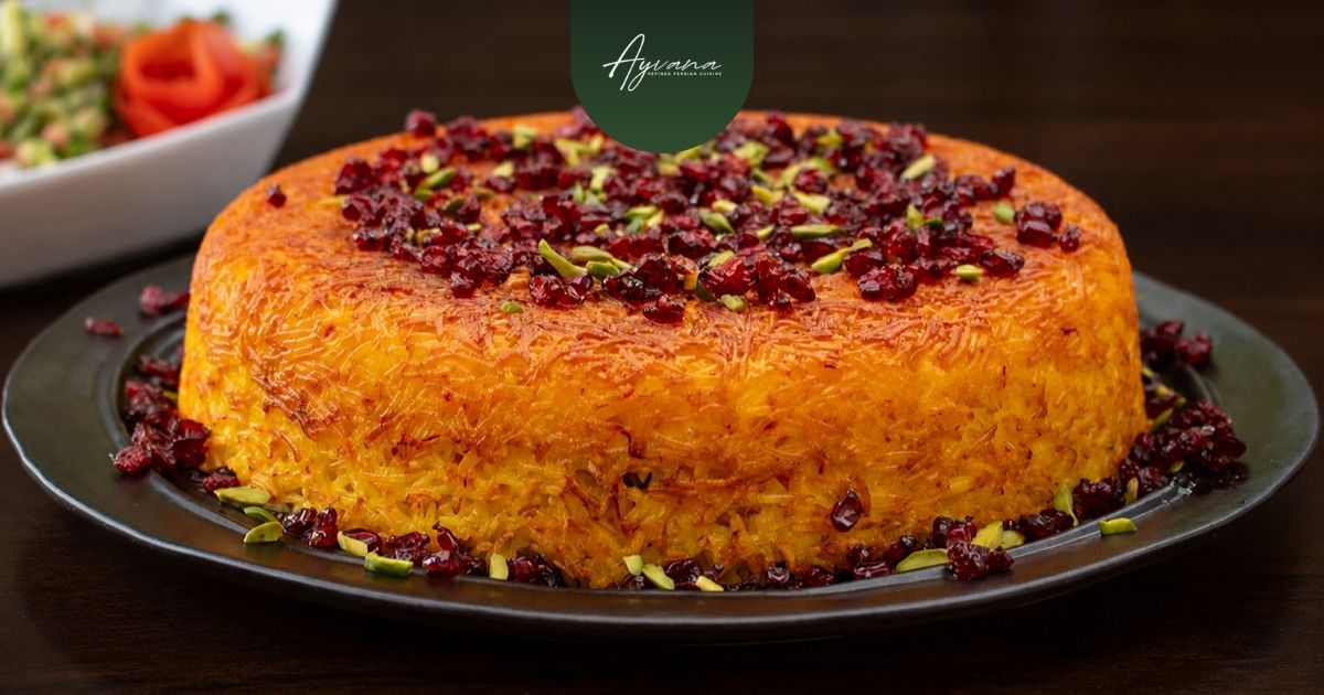 Golden Persian tahchin topped with pistachios and barberries served as traditional saffron rice centerpiece at Ayvana restaurant.